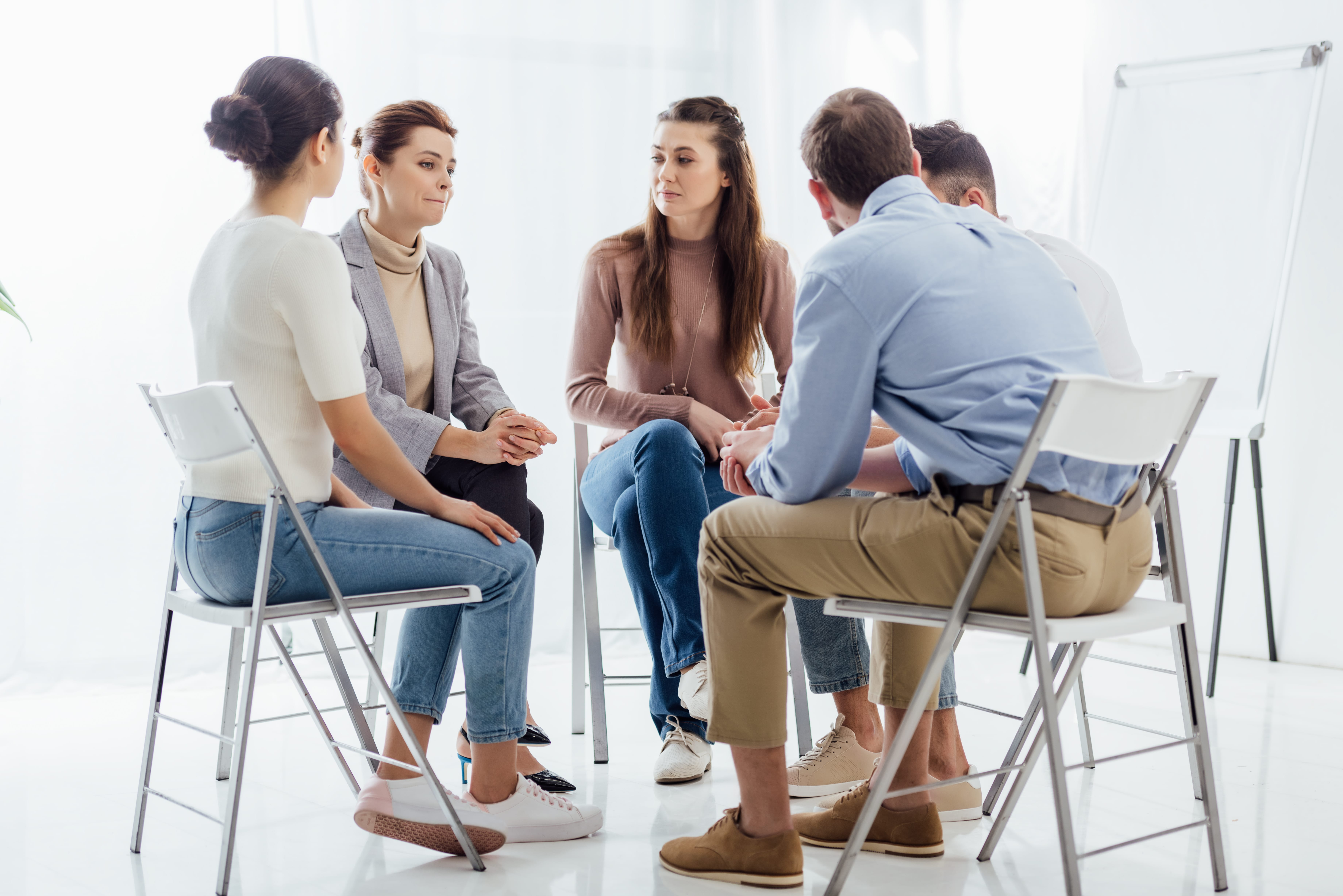 people sitting in a circle during group therapy session for mental health and addiction recovery
